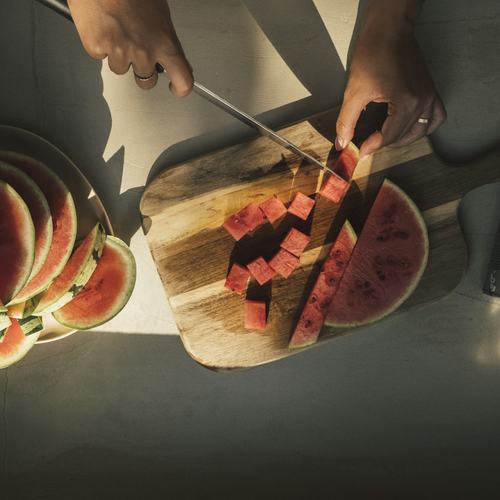 Hands slicing fresh fruit for drying